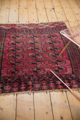 Multiple minor geometric borders with fuchsia and navy elephant footprint guls, low pile and tattered edge.