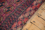 Antique Turkmen rug's fuchsia geometric pattern, minor border, tattered fringe, and patch.
