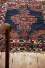 Antique Afshar rug detail: dark blue, red, ivory tree-of-life motifs, and light tattered end.