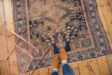 Worn geometric patterns of antique Afshar rug border in navy, apricot, and sky blue.