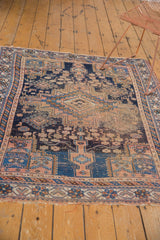 Lower edge of the antique Afshar rug, with tattered fringe and navy, apricot geometric border.