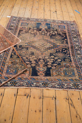 Antique Afshar rug's lower border showcasing geometric patterns, worn pile, and tattered fringe.