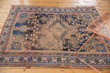Antique Afshar rug corner detail, dark navy, apricot geometric field, patterned border, visible wear.