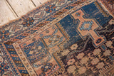 Antique Afshar rug detail: hard wear, tatter, geometric patterns in blue and apricot.