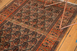 Tangerine orange border and ivory field display fine repeating paisley boteh motifs.