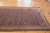 Decorative view of an antique Mission Malayer rug showing its rich navy Herati field and intricate ivory border.