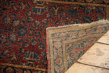 Lilihan rug corner showing deep red floral pile, exposed foundation, and worn tattered edge.