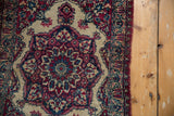 Worn side cord selvage next to the intricate floral and pawn motif border of a Persian rug.