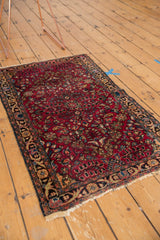 Vintage Lilihan rug with black cherry field, floral vinery, and tattered fringe.