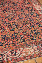 Malayer rug with repeating Herati design in brick red, dark navy, and faded tangerine low pile.