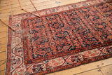 Vintage Malayer rug corner displaying classic Serbend border, navy and faded red Herati motif.