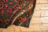 Antique Lilihan rug close-up: main border with samovar elements, dusty raspberry red and sky blue, tattered edge.