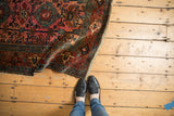 Aged side edge, low pile, and traditional patterns of an antique Lilihan rug.
