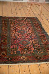 Antique Lilihan rug end with dusty raspberry field, samovar border, and light tattered fringe.