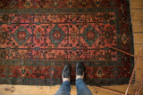 Antique Lilihan rug's dusty raspberry field, blue medallions, and dark copper border patterns.