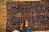 Antique Kurdish Hamadan rug with indigo field, herati pattern, madder red border, and storied pile.