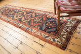 Geometric border and light tatter on the end of an antique Northwest Persian runner.