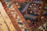 Intricate madder root red and ivory geometric border transitions to a navy field on the Persian runner.