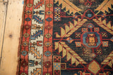 Antique Northwest Persian runner's edge: madder red border, ivory geometric, and navy serrated leaves.