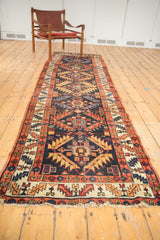 Detail of antique Northwest Persian runner's navy field, serrated leaf border, and aged fringe.