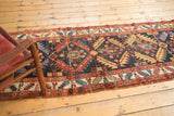 Antique Northwest Persian runner's dark navy field, madder red serrated leaf lattice, and light tatter.