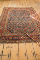The antique Fereghan rug's secured end and rich madder red traditional border.
