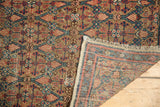 Folded corner of antique Persian Serab runner, revealing hand-knotted back and paneled lattice design.