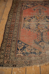Antique Kurdish Malayer rug corner, showing worn selvage, tattered fringe, and floral borders.