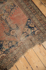 Antique Kurdish Malayer rug's worn side selvage and tattered end, showcasing pinwheel floral border.