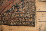 Antique Kurdish Malayer rug folded corner with pinwheel border, vine motif, and tattered fringe.