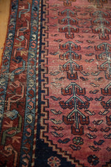 Antique Lilihan fragment: faded raspberry field, germinating plant motifs, navy border, worn pile.