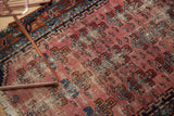 Antique Lilihan rug detail: raspberry and navy germinating plant motifs, even wear.