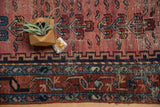 Antique Lilihan rug border with geometric navy blue and raspberry motifs, showing mostly even wear.