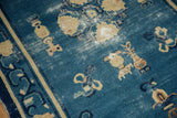 Worn denim blue field of antique Chinese Peking rug, showing ivory Taoist urns and border.