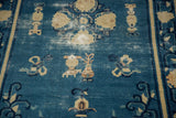 Antique Peking rug's denim blue field with symbolic urns, faded floral motifs, mostly even wear.