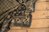 Finely woven geometric pattern and worn selvage of an antique Shirvan rug.