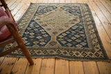 Antique Shirvan rug corner, showing dark navy geometric patterns and worn end.