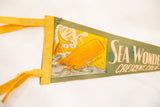 Green felt pennant detail: yellow binding tape, orange whale graphic, and 'Sea Wonders' text.