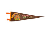 A vintage Victoria Canada felt pennant in brown with colorful maple leaves and bright orange ties.