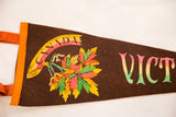 Detail of the colorful maple leaf graphic on the brown felt Victoria Canada pennant.