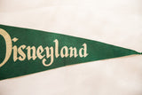 Green felt vintage Disneyland pennant with cream 'neyland' text and a visible crease.