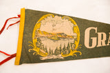 Vintage Grants Pass Oregon Crater Lake felt pennant's yellow border, red ties, and ornate graphic.