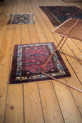 Vintage Engelas rug with cherry red and navy tones, styled in a room on a wood floor.