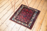 Angled view of a vintage Engelas rug with a traditional red and navy blue allover Herati design.