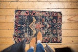 Worn antique Lilihan rug featuring a faded denim blue field and prominent tree of life motif.