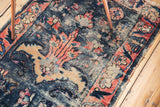 Visible pile wear and oversized floral motifs on the antique Lilihan rug.