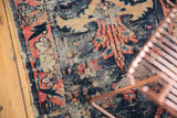 Antique Lilihan rug detail: worn navy, rose, ivory floral design and tattered edge.