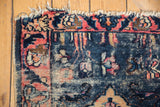 Antique Persian Lilihan rug with worn navy blue pile, tattered fringe, raspberry rose motifs.