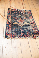 Tattered fringe and worn navy, rose, and ivory floral border of an antique Lilihan rug.