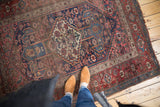 Antique Kurdish Bijar rug, geometric flower blossoms in rich blues, reds, ivory, aged texture.
